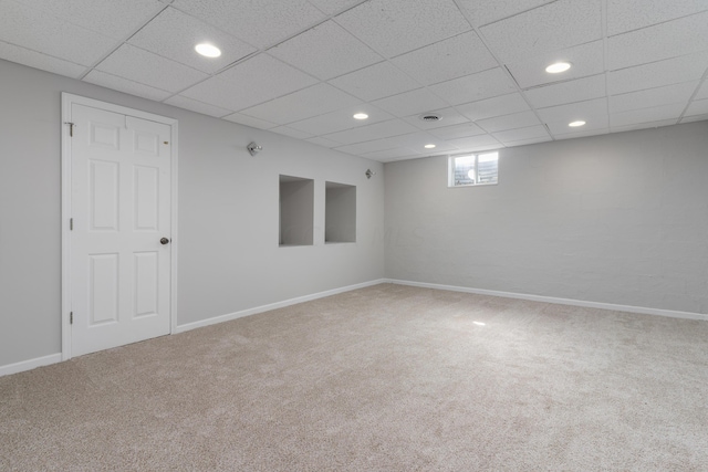 basement with a drop ceiling and carpet floors