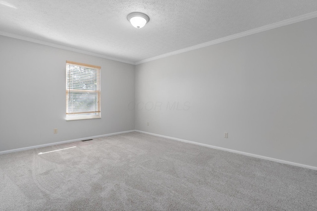 carpeted empty room with ornamental molding and a textured ceiling