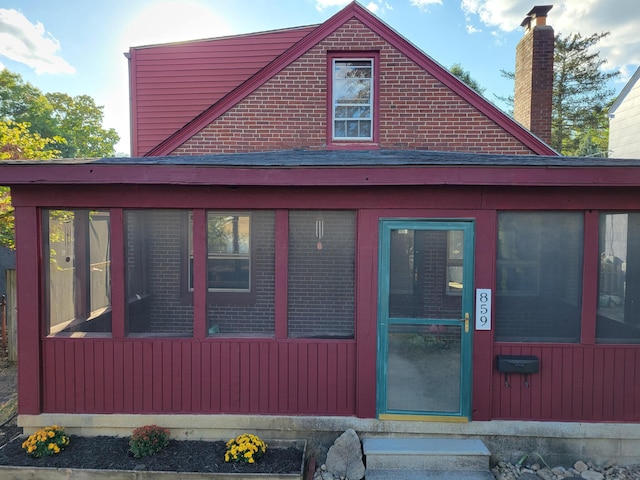 view of side of home featuring a sunroom