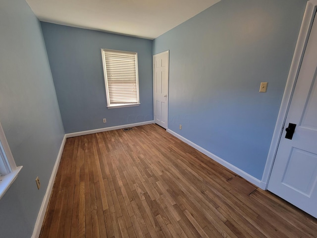 unfurnished room with hardwood / wood-style flooring