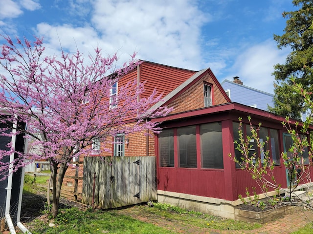 859 Gladden Rd, Grandview Heights, OH 43212 - view of side of property with a sunroom, fence, and brick siding