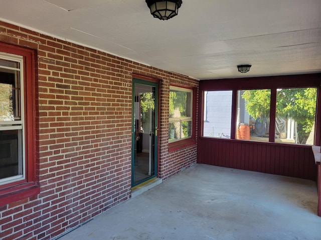 859 Gladden Rd, Grandview Heights, OH 43212 - unfurnished sunroom featuring brick wall and unfinished concrete flooring