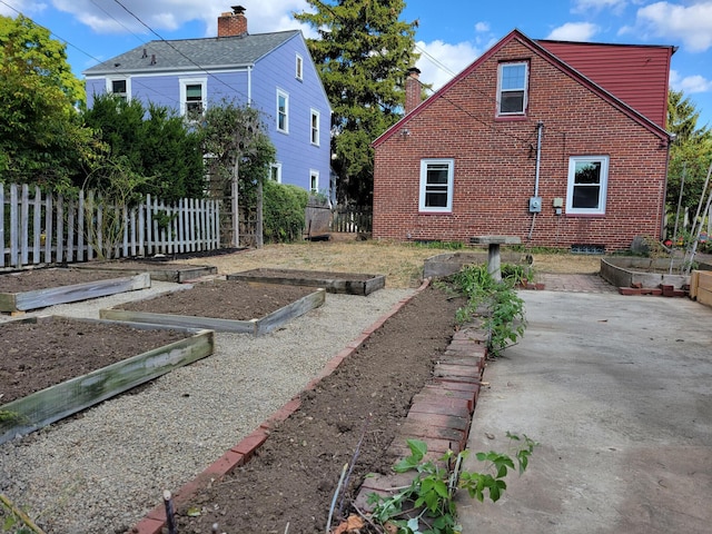 859 Gladden Rd, Grandview Heights, OH 43212 - view of side of property featuring a vegetable garden, brick siding, fence, and a patio