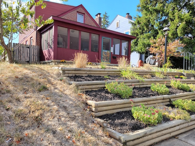 859 Gladden Rd, Grandview Heights, OH 43212 - rear view of house with a vegetable garden, a sunroom, fence, and a chimney