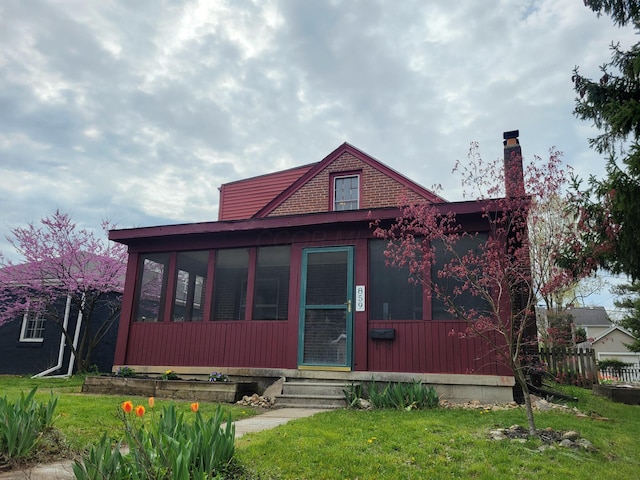 859 Gladden Rd, Grandview Heights, OH 43212 - view of front of house featuring entry steps, a front lawn, a sunroom, and a chimney