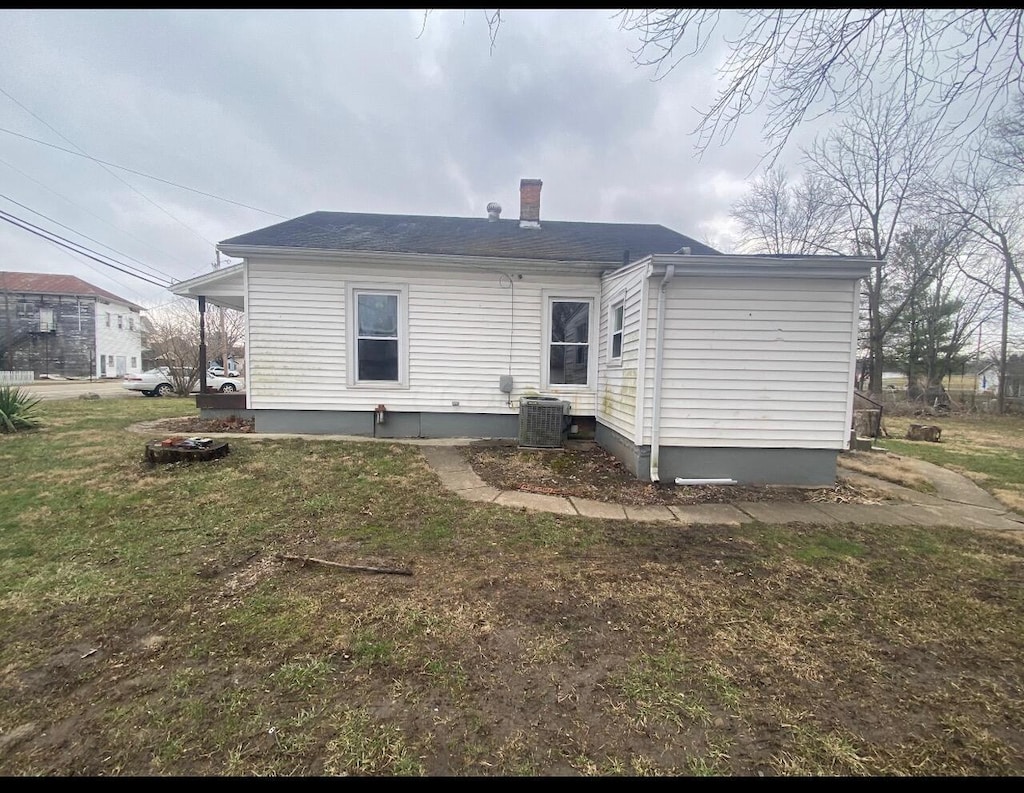 back of house with a yard and central air condition unit