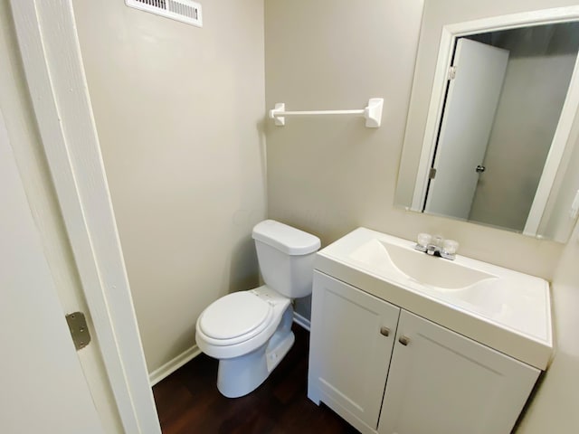 bathroom featuring toilet, wood-type flooring, and vanity