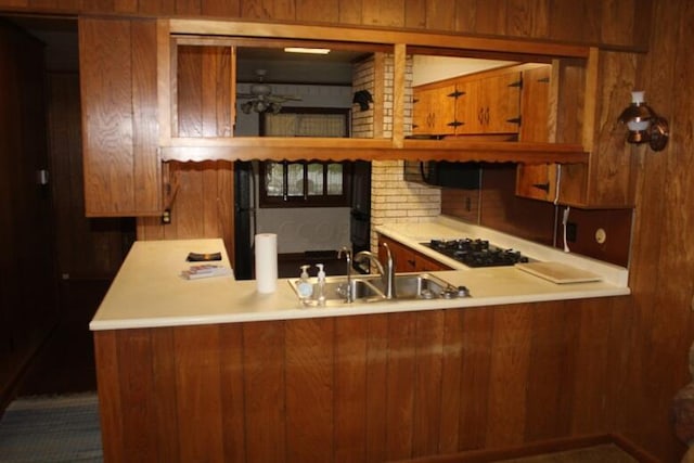 kitchen featuring kitchen peninsula, black gas stovetop, and sink