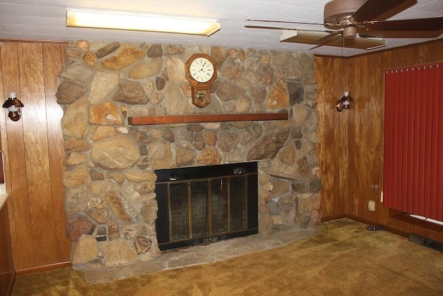 room details with a fireplace, carpet flooring, ceiling fan, and wooden walls