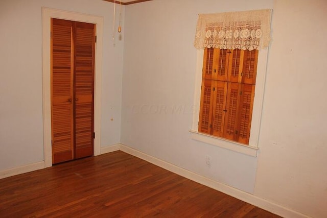 unfurnished bedroom featuring a closet and dark hardwood / wood-style floors