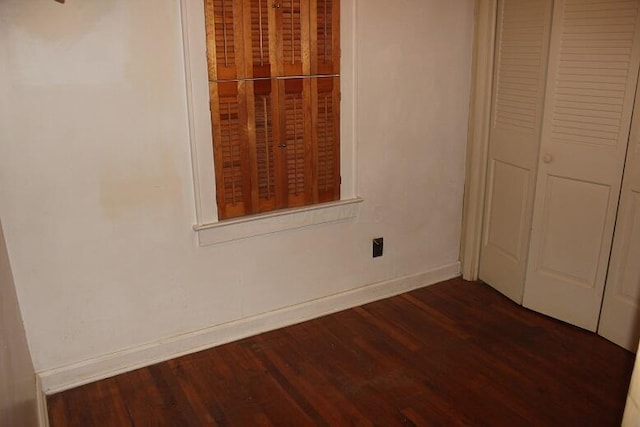 unfurnished bedroom featuring a closet and dark hardwood / wood-style flooring