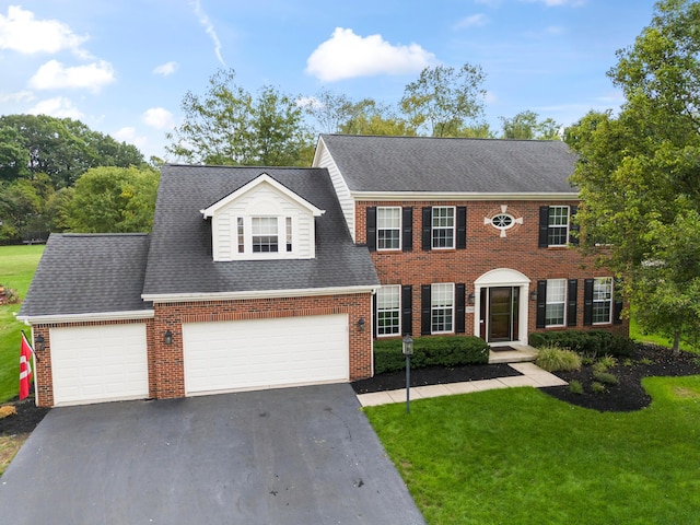 colonial-style house featuring a front lawn and a garage