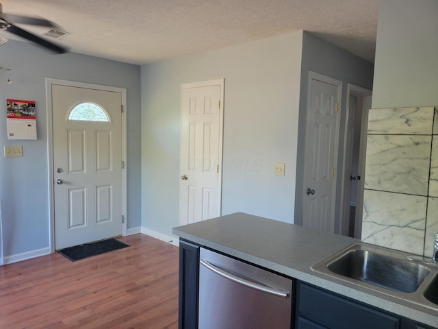 kitchen featuring ceiling fan, dishwasher, sink, a textured ceiling, and hardwood / wood-style flooring