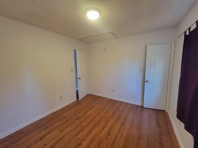 unfurnished room featuring a textured ceiling and light hardwood / wood-style flooring