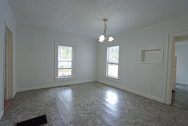 unfurnished room featuring a textured ceiling, crown molding, a notable chandelier, and a stone fireplace