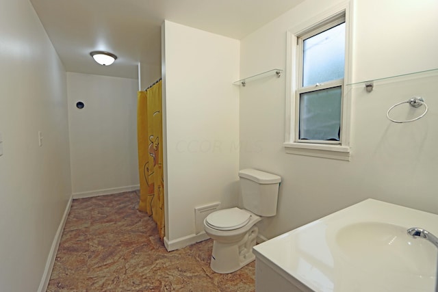 bathroom with curtained shower, vanity, and toilet