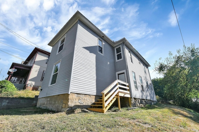 rear view of house featuring a lawn