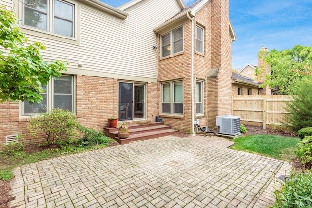 back of property with a patio area and central AC