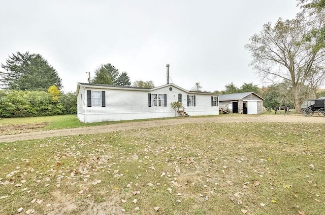 manufactured / mobile home with a front lawn and a shed