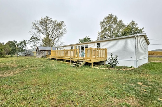 rear view of property featuring a wooden deck and a yard