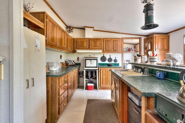 kitchen featuring light tile patterned flooring, crown molding, lofted ceiling, and sink