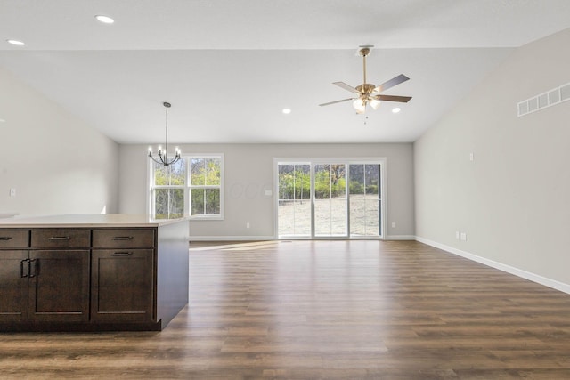 kitchen with hanging light fixtures, dark hardwood / wood-style floors, dark brown cabinetry, ceiling fan with notable chandelier, and vaulted ceiling