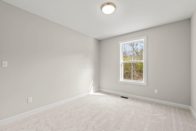 spare room featuring light carpet