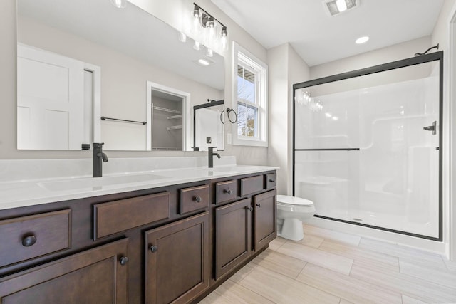 bathroom with vanity, an enclosed shower, and toilet