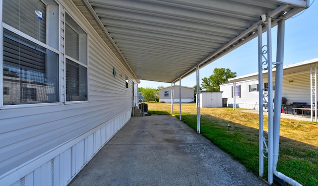 exterior space with a storage shed, a yard, and a carport