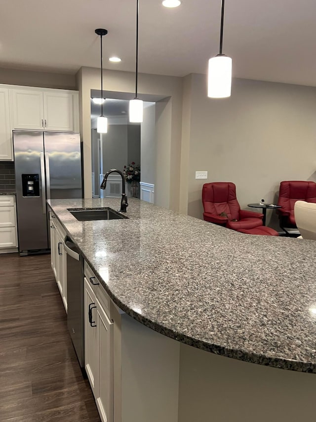 kitchen featuring white cabinets, sink, dark hardwood / wood-style floors, dark stone countertops, and stainless steel appliances