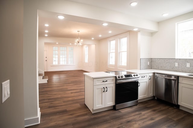 kitchen featuring kitchen peninsula, white cabinets, stainless steel appliances, and dark hardwood / wood-style floors