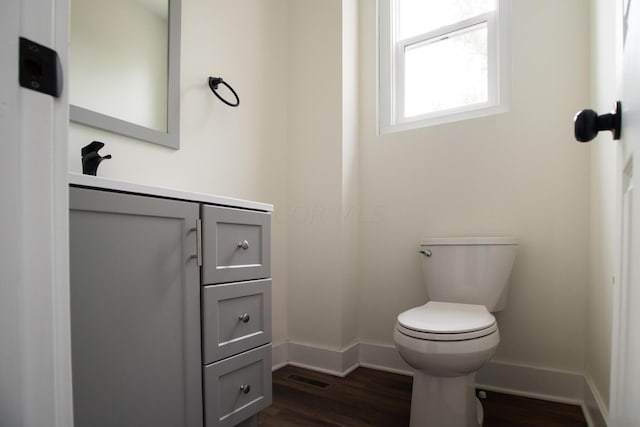 bathroom with hardwood / wood-style floors, vanity, and toilet