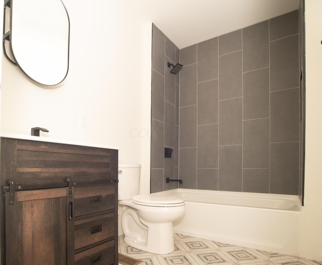 full bathroom with tiled shower / bath, tile patterned floors, vanity, and toilet