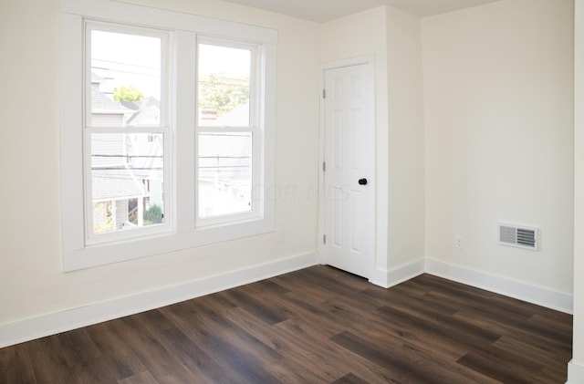 unfurnished room with dark hardwood / wood-style floors and a healthy amount of sunlight