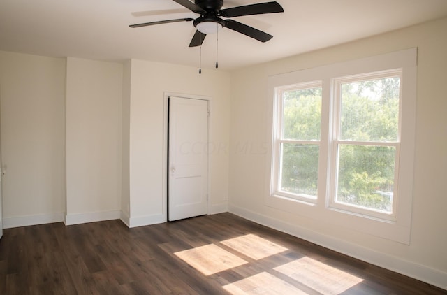 empty room with dark hardwood / wood-style flooring and ceiling fan