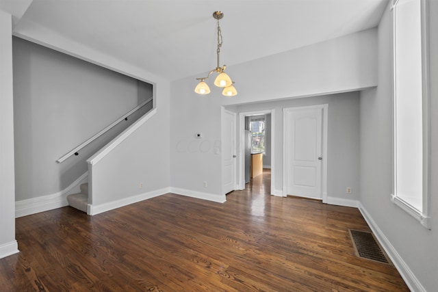 unfurnished dining area featuring dark hardwood / wood-style flooring and a notable chandelier