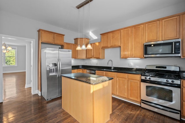 kitchen with decorative light fixtures, a center island, sink, dark wood-type flooring, and stainless steel appliances