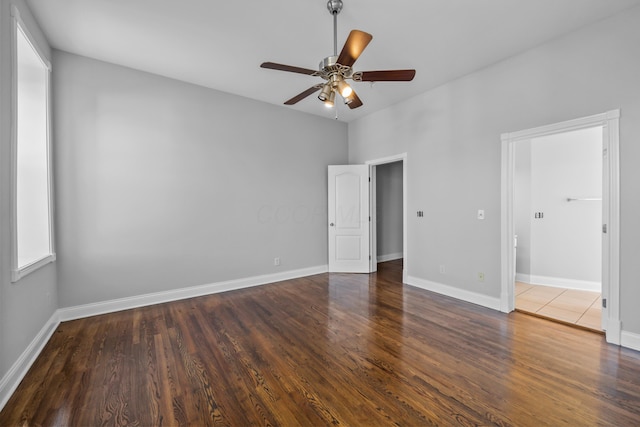 unfurnished bedroom with ceiling fan and dark wood-type flooring