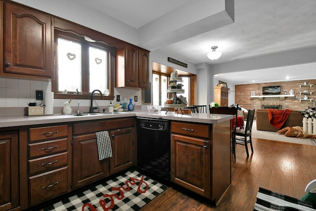 kitchen featuring kitchen peninsula, backsplash, dark wood-type flooring, sink, and black dishwasher