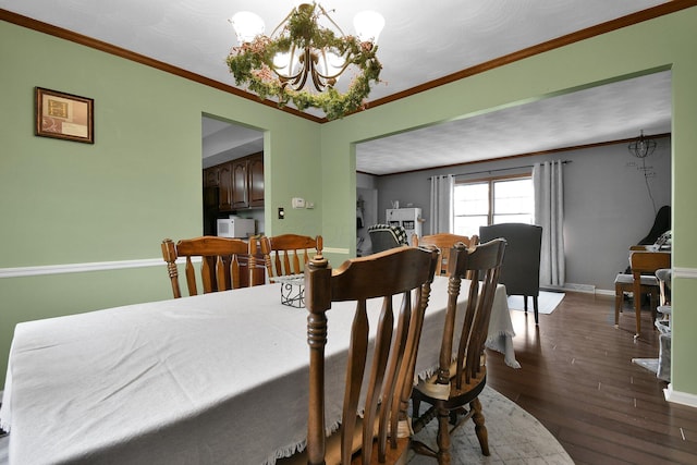 dining area featuring dark hardwood / wood-style floors, ornamental molding, and a chandelier