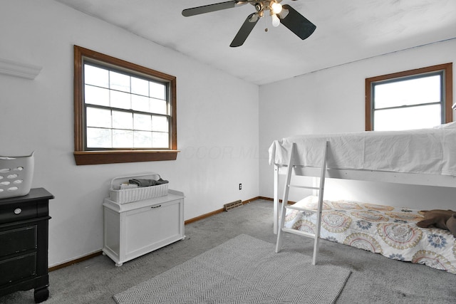 carpeted bedroom with multiple windows and ceiling fan