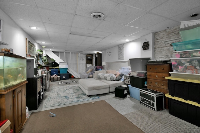 living room with a drop ceiling and light carpet