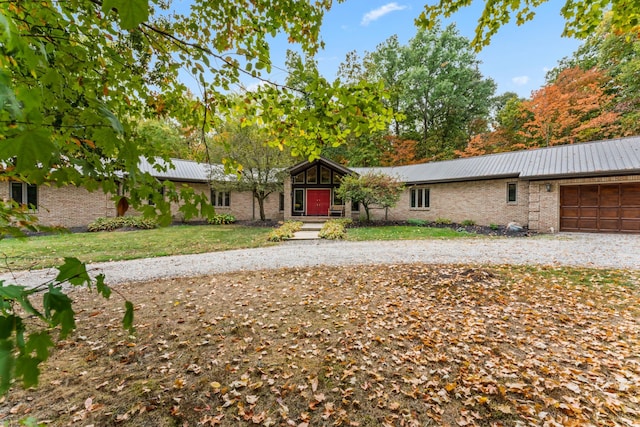 ranch-style house featuring a garage and a front lawn