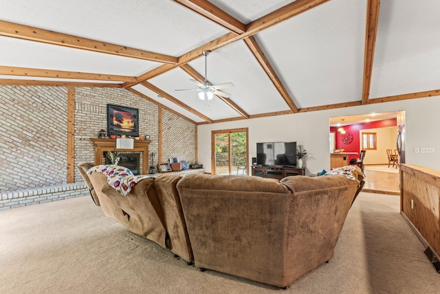 living room with a brick fireplace, brick wall, light colored carpet, ceiling fan, and vaulted ceiling with beams