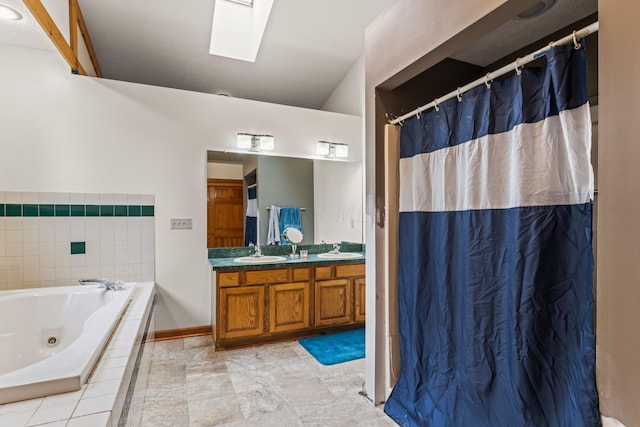 bathroom with vanity, a relaxing tiled tub, and a skylight