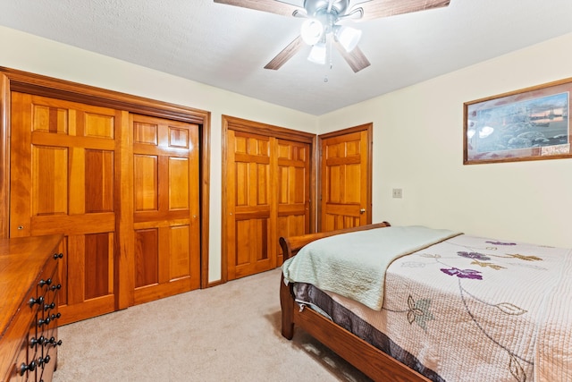 carpeted bedroom with ceiling fan and a textured ceiling