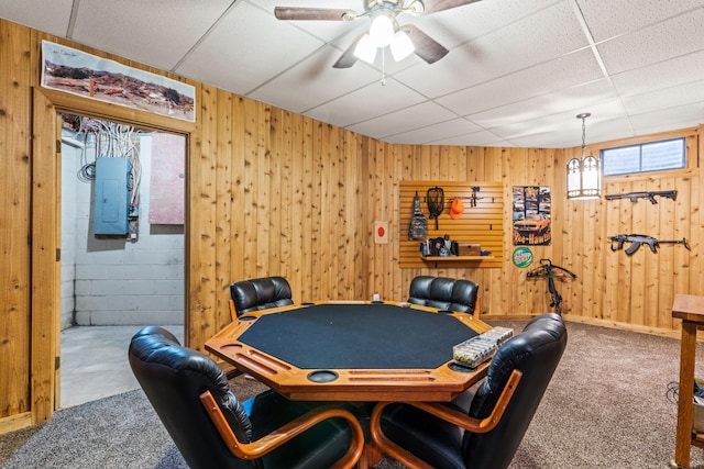 playroom with carpet, a drop ceiling, and wooden walls