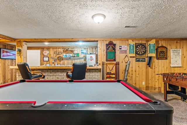 rec room featuring carpet flooring, a textured ceiling, wood walls, and pool table