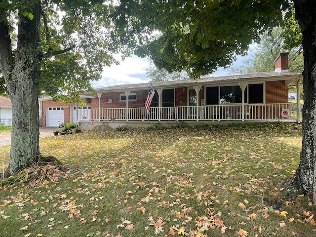 single story home featuring a garage, an outbuilding, and a front yard