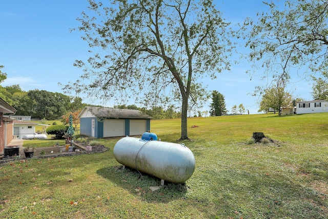 view of yard with a garage, an outdoor structure, and central AC